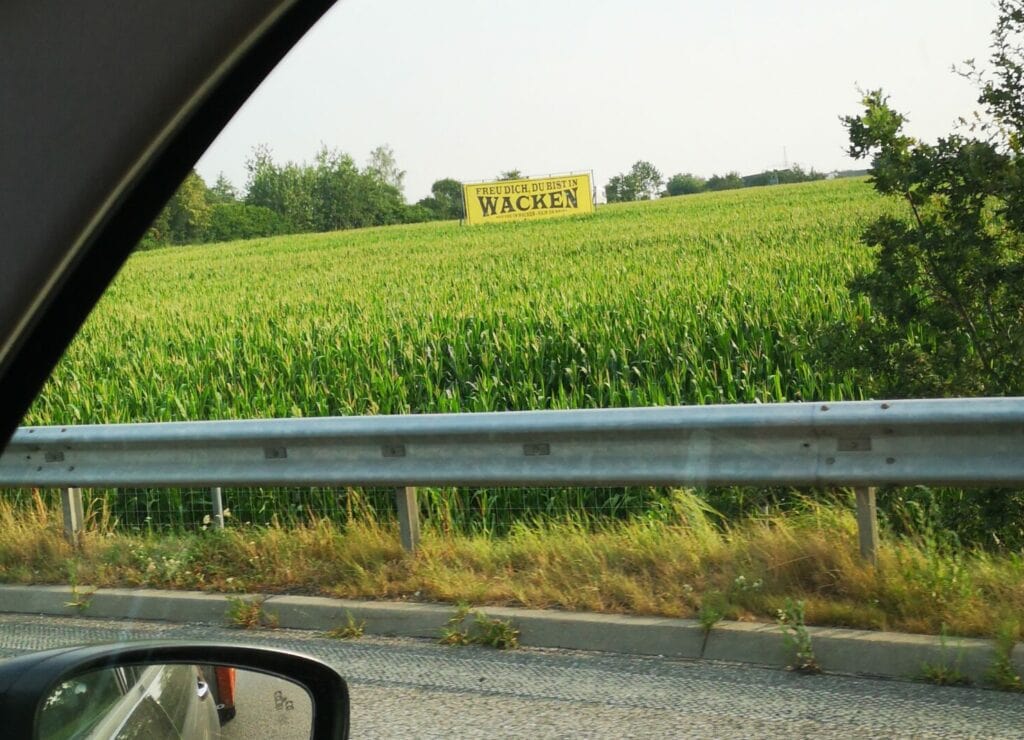 Aus dem Auto ein Wacken-Schild neben der Autobahn